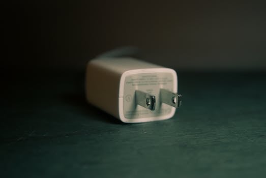 Home A focused view of a white wall charger plug lying on its side indoors.